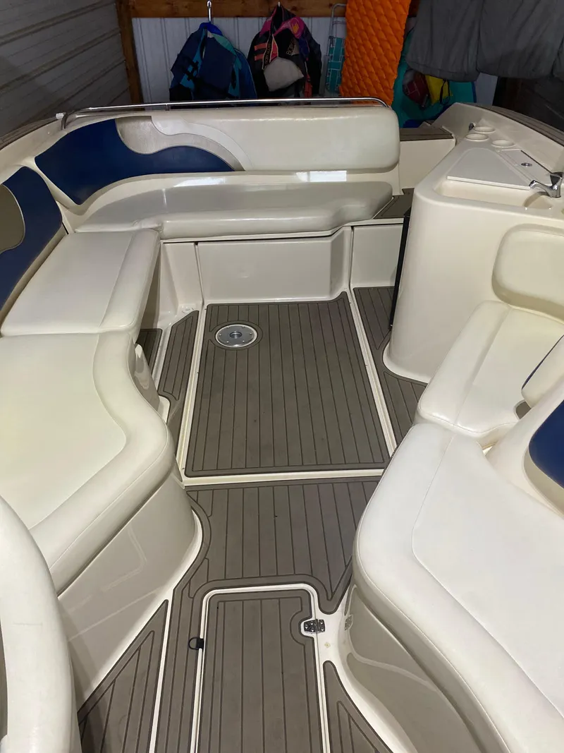 Slide: The Image of 2001 Rinker 272 Captiva boat interior with white and blue seating, gray flooring. - 10