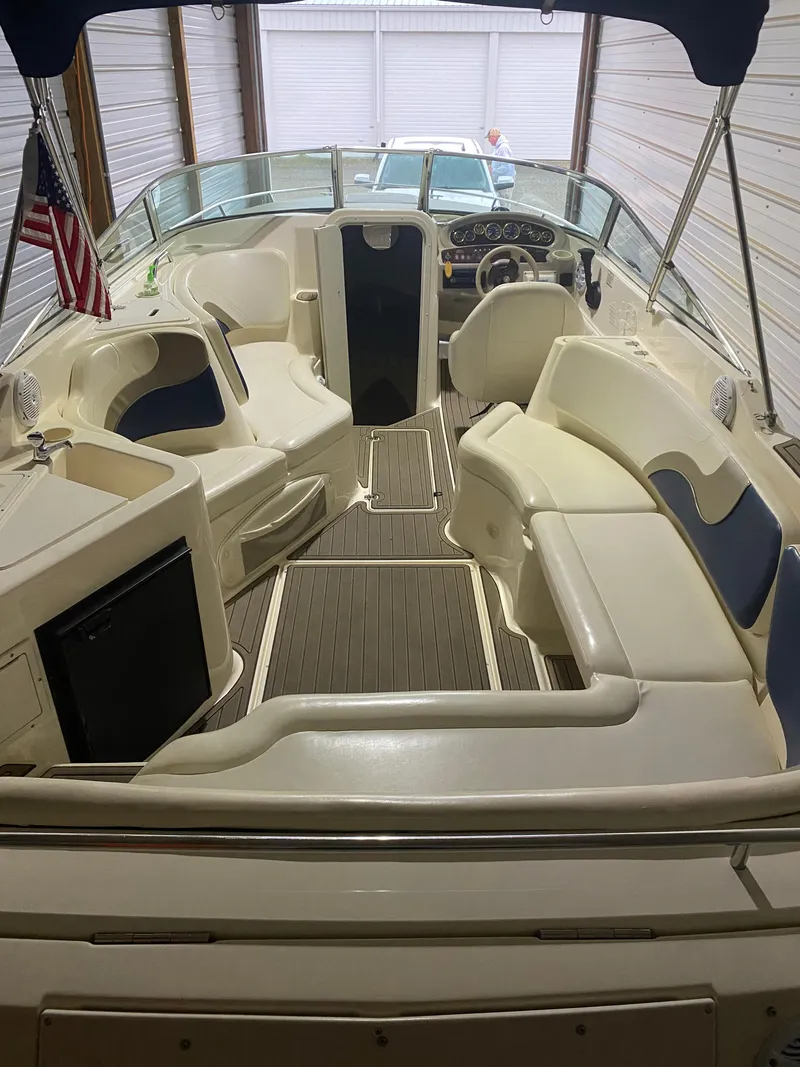 Slide: The Image of 2001 Rinker 272 Captiva boat interior with seating, steering wheel, and American flag. - 11