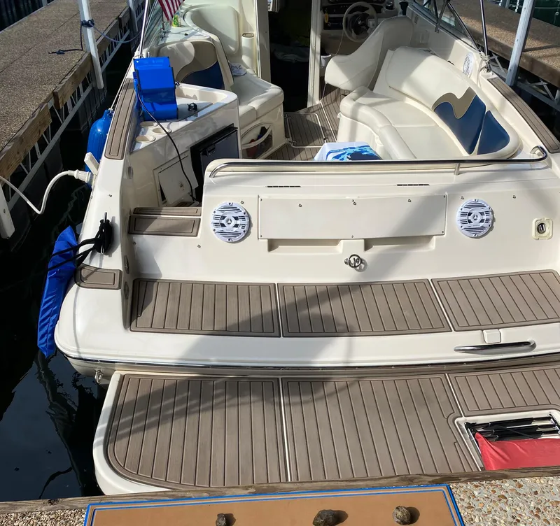 Slide: The Image of 2001 Rinker 272 Captiva boat with spacious deck and seating at a dock. - 15