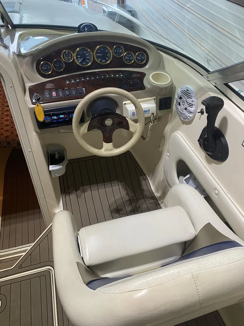 Slide: The Image of 2001 Rinker 272 Captiva boat cockpit with steering wheel and control panel. - 2