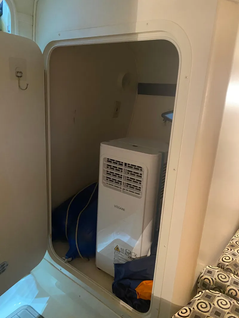 Slide: The Image of 2001 Rinker 272 Captiva cabin with portable air conditioner inside storage compartment. - 9