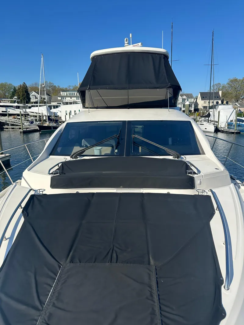 Slide: The Image of 2016 Sea Ray L590 Fly yacht docked in marina, featuring sleek design and spacious flybridge. - 10