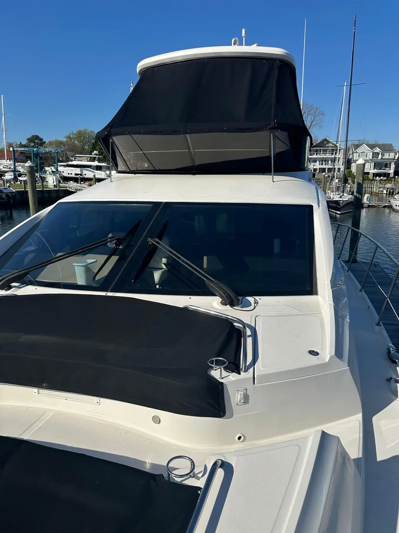 Slide: The Image of 2016 Sea Ray L590 Fly yacht docked at marina, featuring sleek design and flybridge. - 11