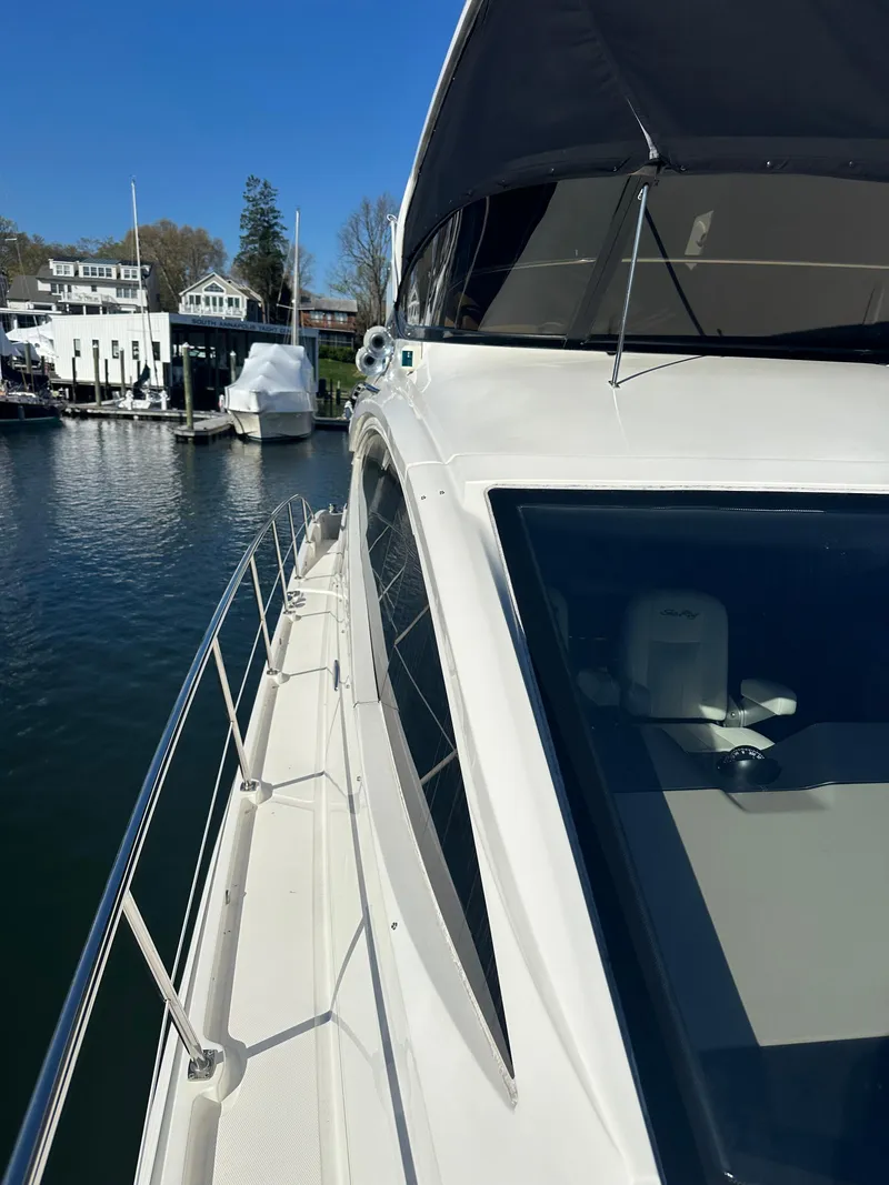 Slide: The Image of 2016 Sea Ray L590 Fly yacht docked at marina, showcasing sleek design and spacious deck. - 12