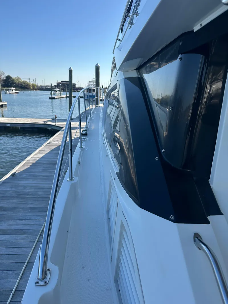 Slide: The Image of 2016 Sea Ray L590 Fly yacht docked at a marina, side view. - 15
