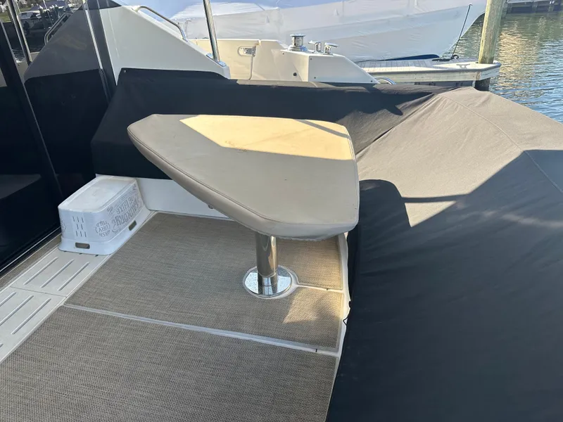 Slide: The Image of 2016 Sea Ray L590 Fly yacht deck with cushioned seating and table. - 16