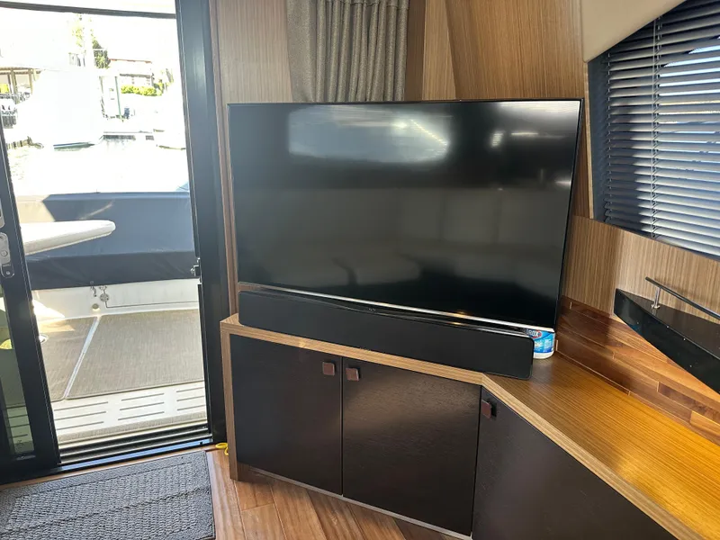 Slide: The Image of Interior of 2016 Sea Ray L590 Fly yacht with TV and modern wood cabinetry. - 17