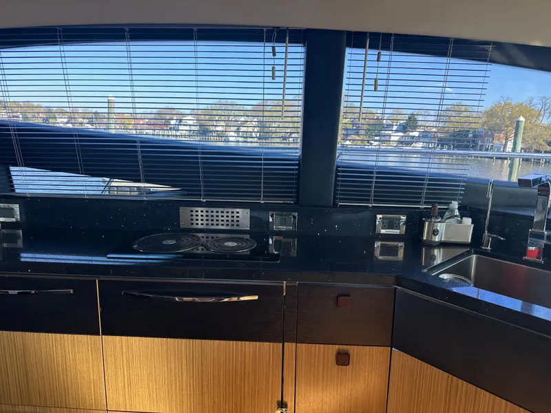Slide: The Image of Interior view of 2016 Sea Ray L590 Fly yacht kitchen with sleek countertops and window blinds. - 22