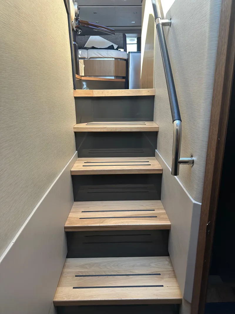 Slide: The Image of Staircase inside 2016 Sea Ray L590 Fly yacht with wooden steps and metal handrail. - 27