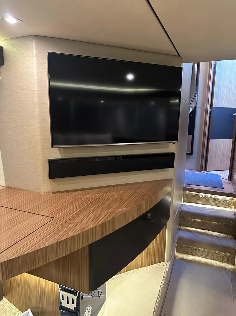 Slide: The Image of Interior of 2016 Sea Ray L590 Fly yacht with modern TV and wooden cabinetry. - 29