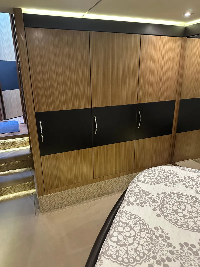 Slide: The Image of 2016 Sea Ray L590 Fly yacht interior with wood paneling and patterned bedding. - 31