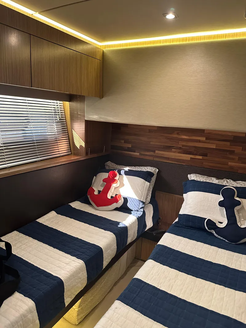 Slide: The Image of 2016 Sea Ray L590 Fly cabin with twin beds, nautical decor, and ambient lighting. - 36