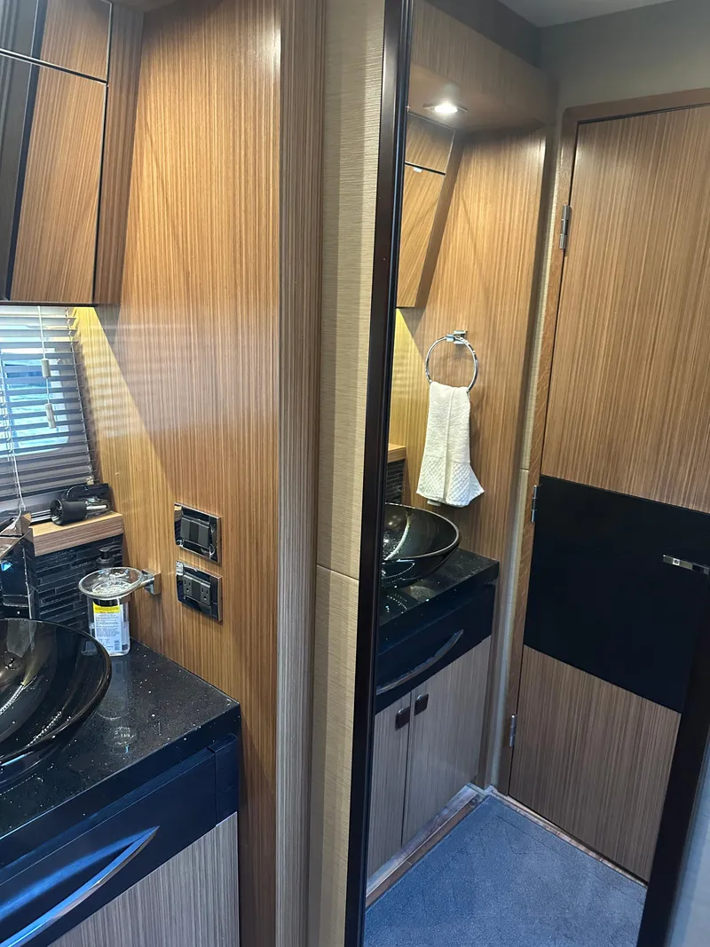 Slide: The Image of 2016 Sea Ray L590 Fly yacht bathroom with wood paneling and modern fixtures. - 38