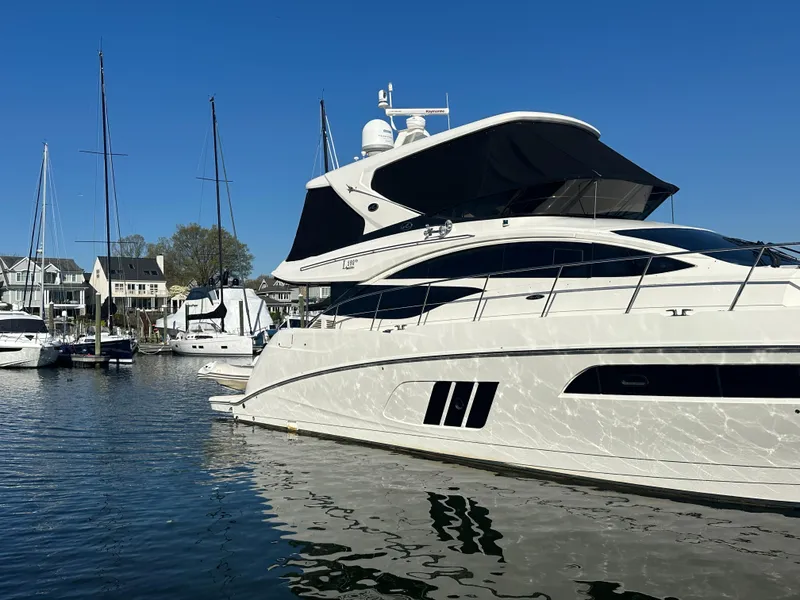 Slide: The Image of 2016 Sea Ray L590 Fly yacht docked in a marina under clear blue skies. - 4