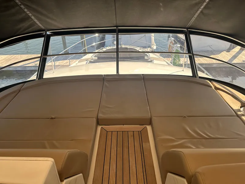 Slide: The Image of 2016 Sea Ray L590 Fly yacht interior with cushioned seating and wooden flooring. - 48
