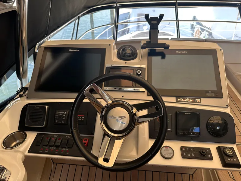 Slide: The Image of Helm of 2016 Sea Ray L590 Fly yacht with dual navigation screens and controls. - 49