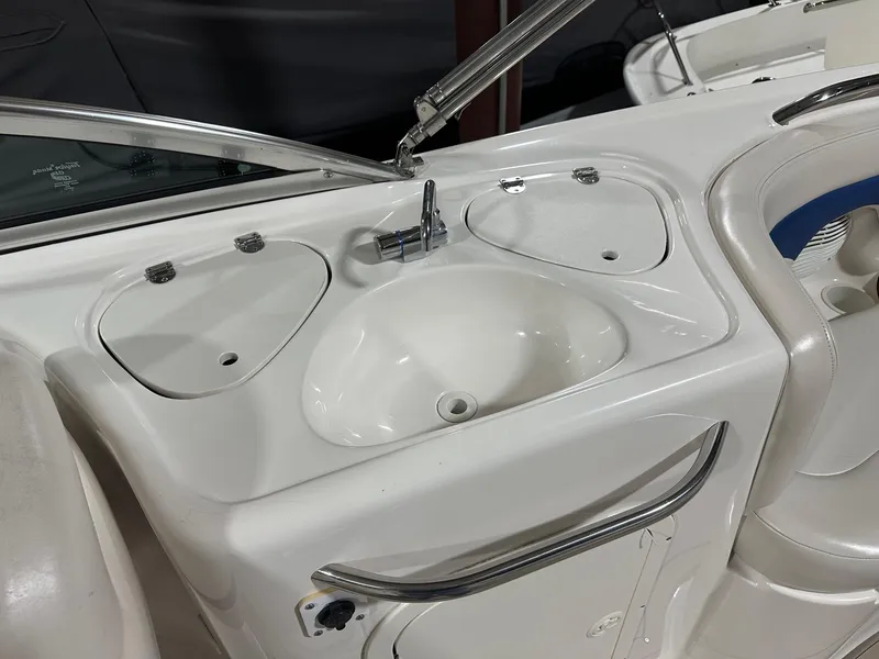 Slide: The Image of 2001 Chaparral Sunesta 263 boat sink and faucet with storage compartments. - 12