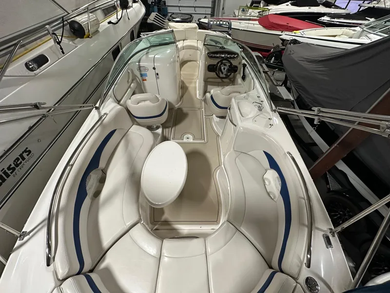 Slide: The Image of 2001 Chaparral Sunesta 263 boat interior with white seating and steering wheel in storage. - 18