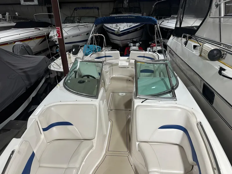 Slide: The Image of 2001 Chaparral Sunesta 263 boat with white and blue seating, docked indoors. - 27