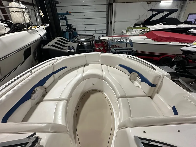 Slide: The Image of 2001 Chaparral Sunesta 263 boat interior with white seating in a storage facility. - 28