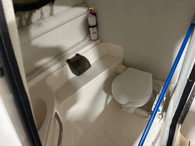 Slide: The Image of 2001 Chaparral Sunesta 263 boat bathroom with toilet and fire extinguisher. - 31