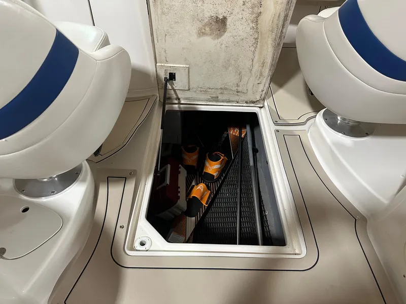 Slide: The Image of 2001 Chaparral Sunesta 263 boat interior with open storage compartment and water sports equipment. - 33