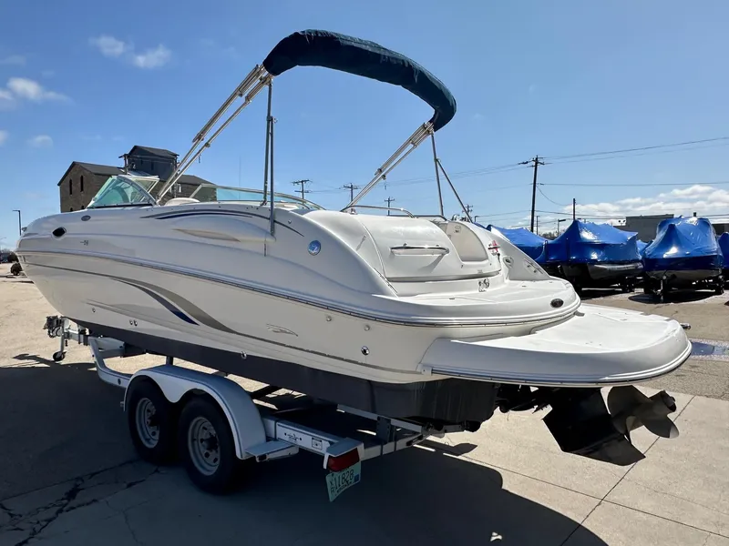 Slide: The Image of 2001 Chaparral Sunesta 263 boat on trailer, featuring a sleek white design and bimini top. - 5
