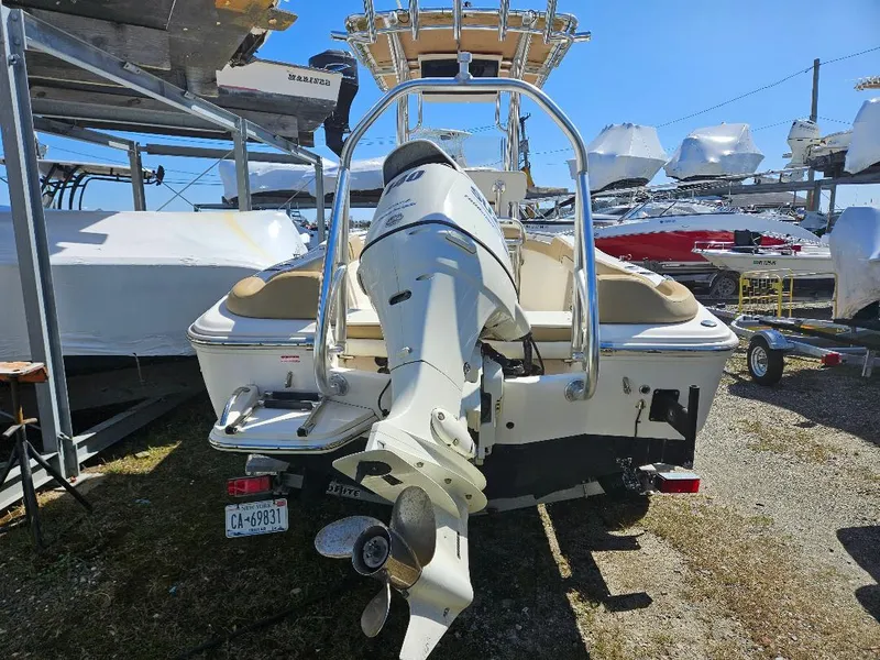 Slide: The Image of 2015 Pioneer Islander 197 boat with outboard motor, parked in a marina storage area. - 12