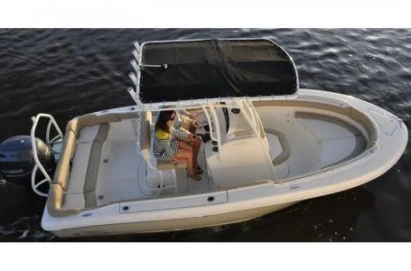 Slide: The Image of 2015 Pioneer Islander 197 boat on water, featuring a canopy and seating area. - 13