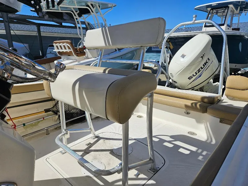 Slide: The Image of 2015 Pioneer Islander 197 boat interior with Suzuki outboard motor, featuring beige seating and chrome details. - 7