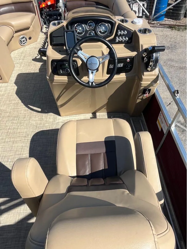 Slide: The Image of Captain's seat and helm of 2019 Lowe SS230W pontoon boat, featuring beige upholstery and controls. - 3