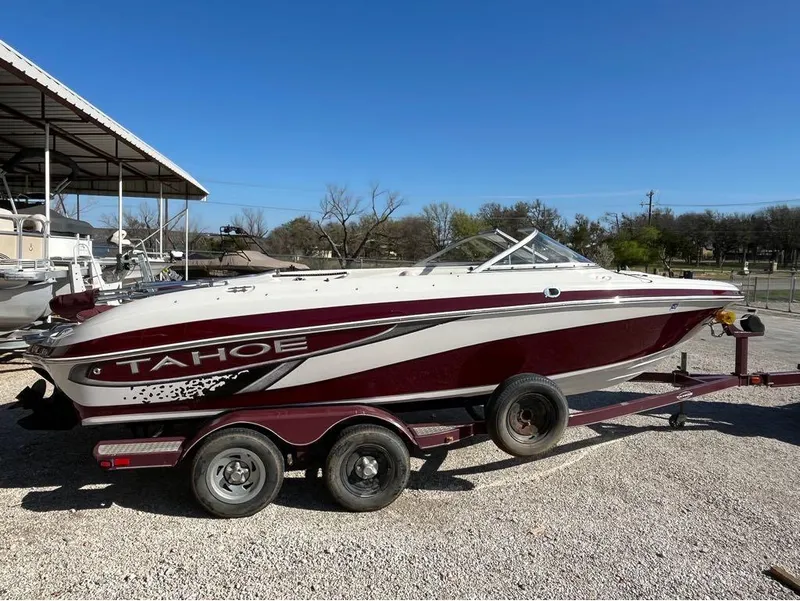 Slide: The Image of 2009 Tahoe Q71SSF boat on trailer, parked outdoors under clear blue sky. - 1