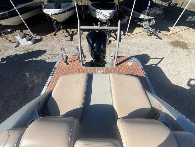 Slide: The Image of 2013 Berkshire 250 Sport BP3 boat with beige seating and outboard motor, parked among other boats. - 7