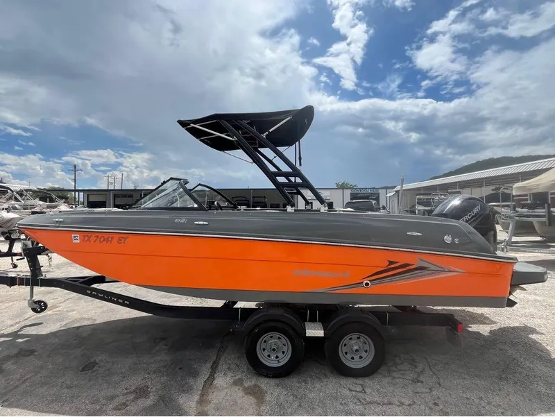 Slide: The Image of 2019 Bayliner 210 EL boat with orange hull on trailer under cloudy sky. - 3