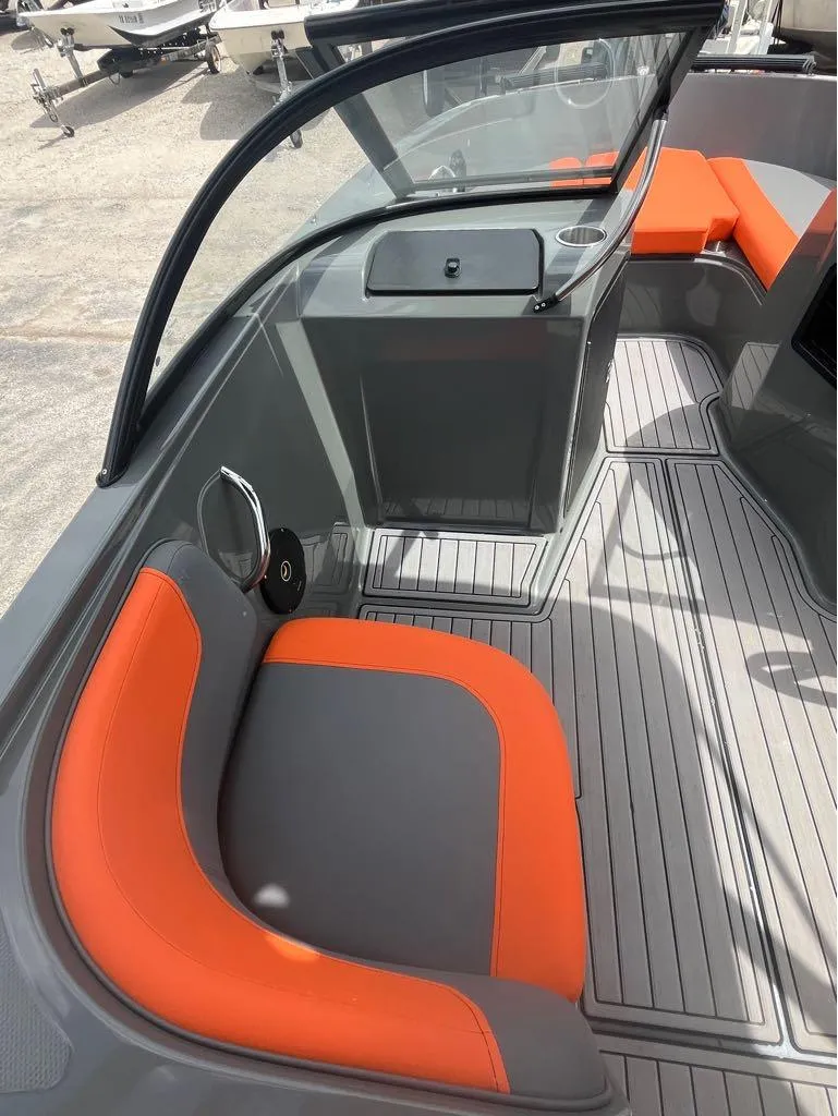 Slide: The Image of 2019 Bayliner 210 EL boat interior with orange and gray seating, modern design. - 5