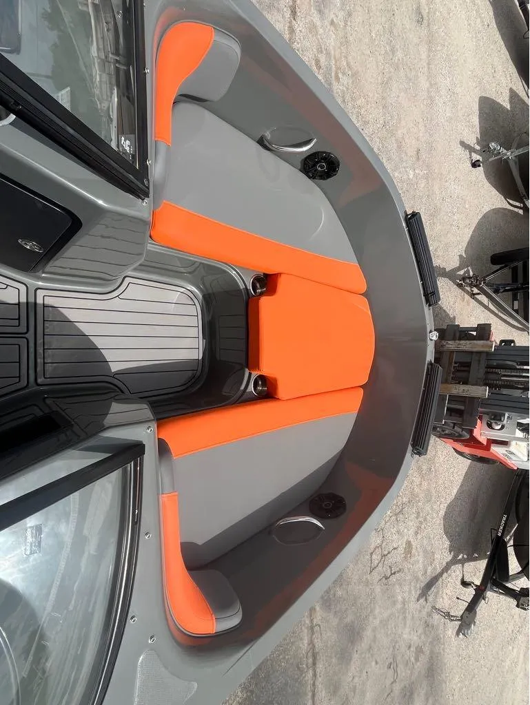 Slide: The Image of 2019 Bayliner 210 EL boat interior with orange and gray seating. - 8
