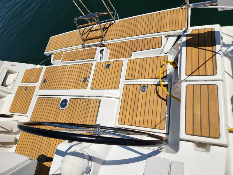 Slide: The Image of Teak deck of 2013 Beneteau Oceanis 41 sailboat with steering wheel and ladder. - 21