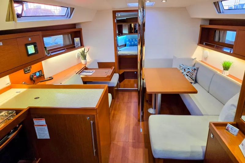 Slide: The Image of Interior of 2013 Beneteau Oceanis 41 yacht, featuring modern wood finish and cozy seating area. - 23