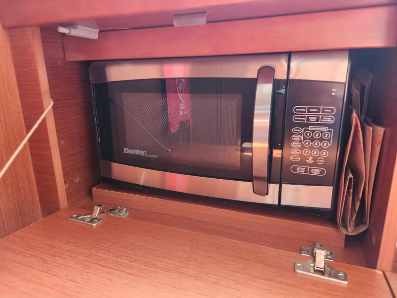 Slide: The Image of Microwave inside a 2013 Beneteau Oceanis 41 yacht's wooden cabinet. - 27