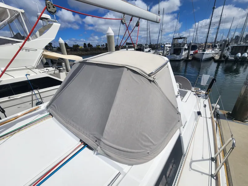 Slide: The Image of 2013 Beneteau Oceanis 41 sailboat with cockpit cover, docked in a marina under blue skies. - 5