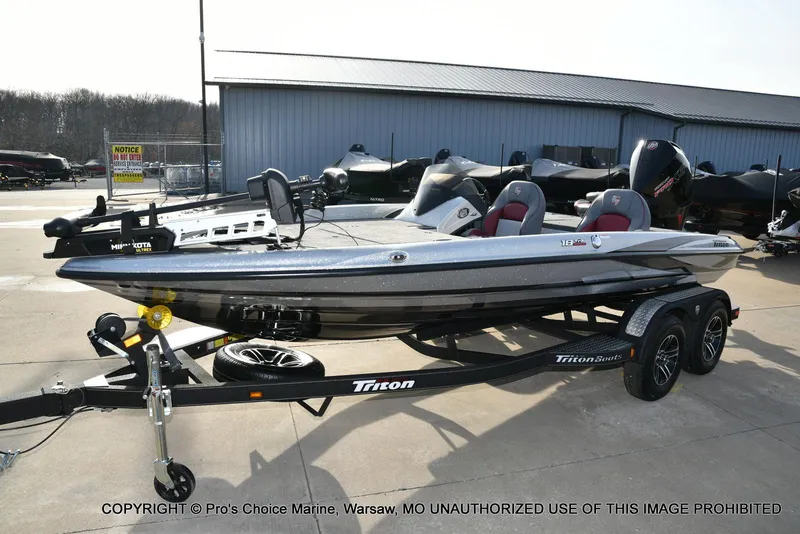 Slide: The Image of 2024 Triton 18 TRX w/200 Pro-XS bass boat on trailer, parked outdoors. - 22