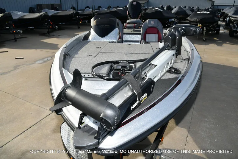 Slide: The Image of 2024 Triton 18 TRX boat with Minn Kota trolling motor, parked outdoors. - 25