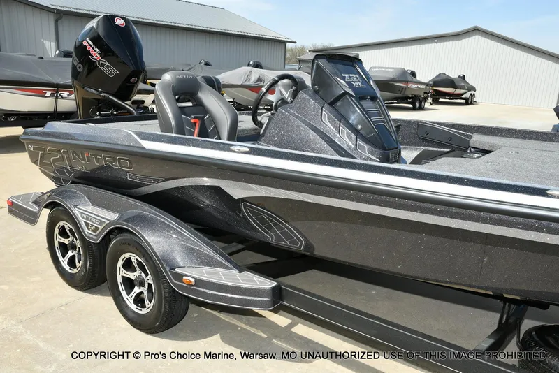 Slide: The Image of 2022 Nitro Z21 XL Pro bass boat with sleek design and dual axle trailer. - 14