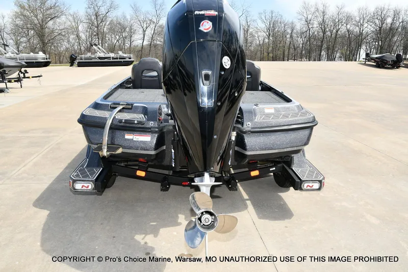 Slide: The Image of 2022 Nitro Z21 XL Pro boat, rear view with motor, parked on concrete. - 26