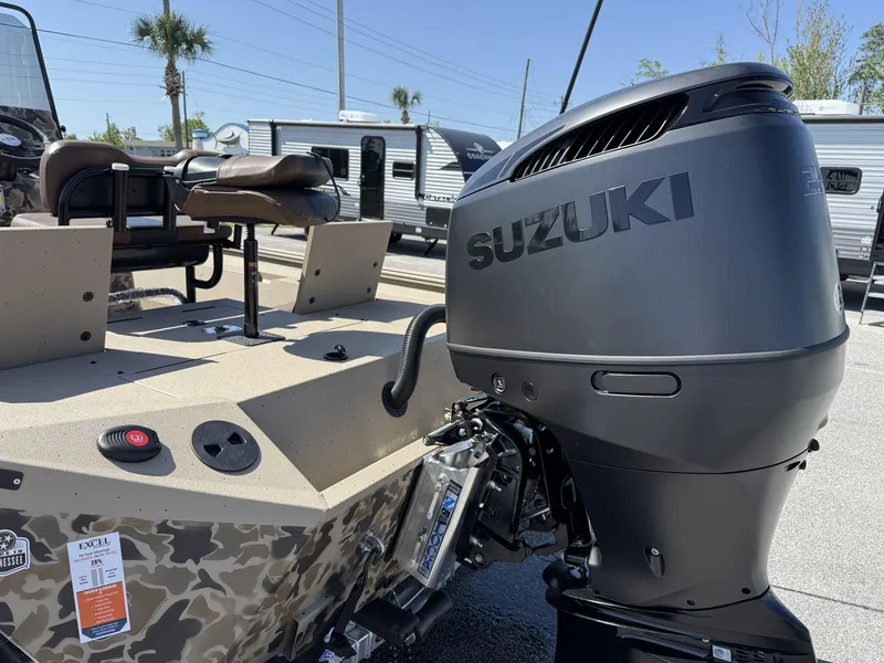 Slide: The Image of 2025 Excel New Bay Pro 230 boat with Suzuki outboard motor, parked outdoors. - 4
