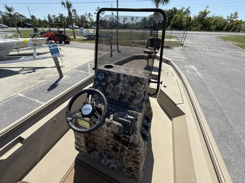 Slide: The Image of 2025 Excel New Bay Pro 230 boat interior with camouflage console and steering wheel. - 6