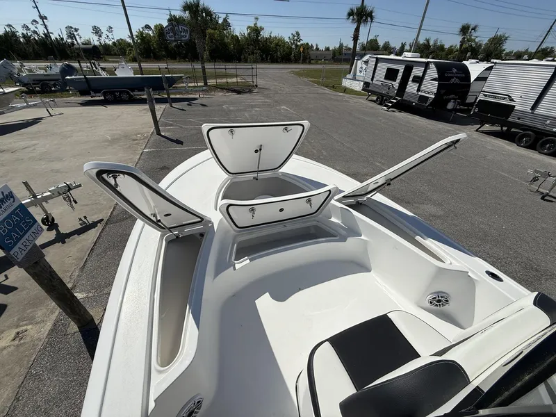 Slide: The Image of 2025 Tidewater 2410 Bay Max boat with open storage compartments in a sales lot. - 10