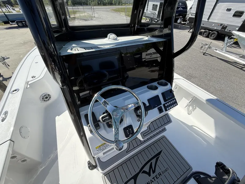 Slide: The Image of 2025 Tidewater 2410 Bay Max boat console with steering wheel and controls. - 13