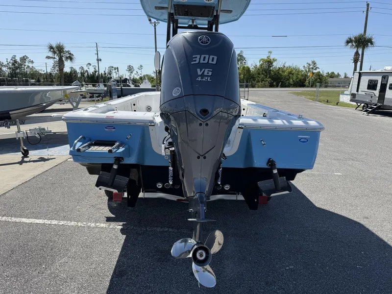 Slide: The Image of 2025 Tidewater 2410 Bay Max boat with 300 V6 engine, parked outdoors. - 5