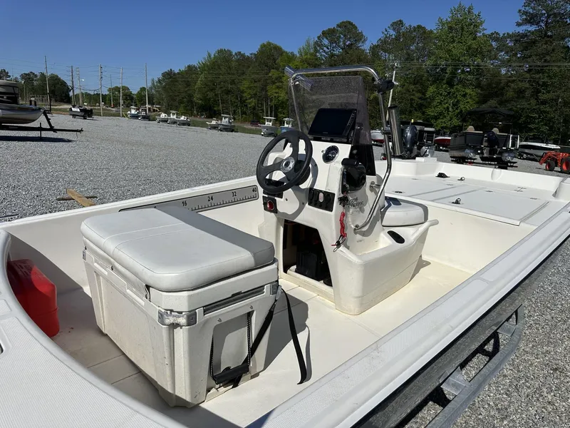 Slide: The Image of 2019 Mako Pro Skiff 17 boat with console and seating, parked on gravel lot. - 7